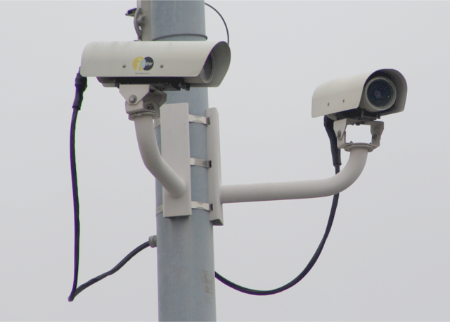 Two cylindrical surveillance cameras on a pole.